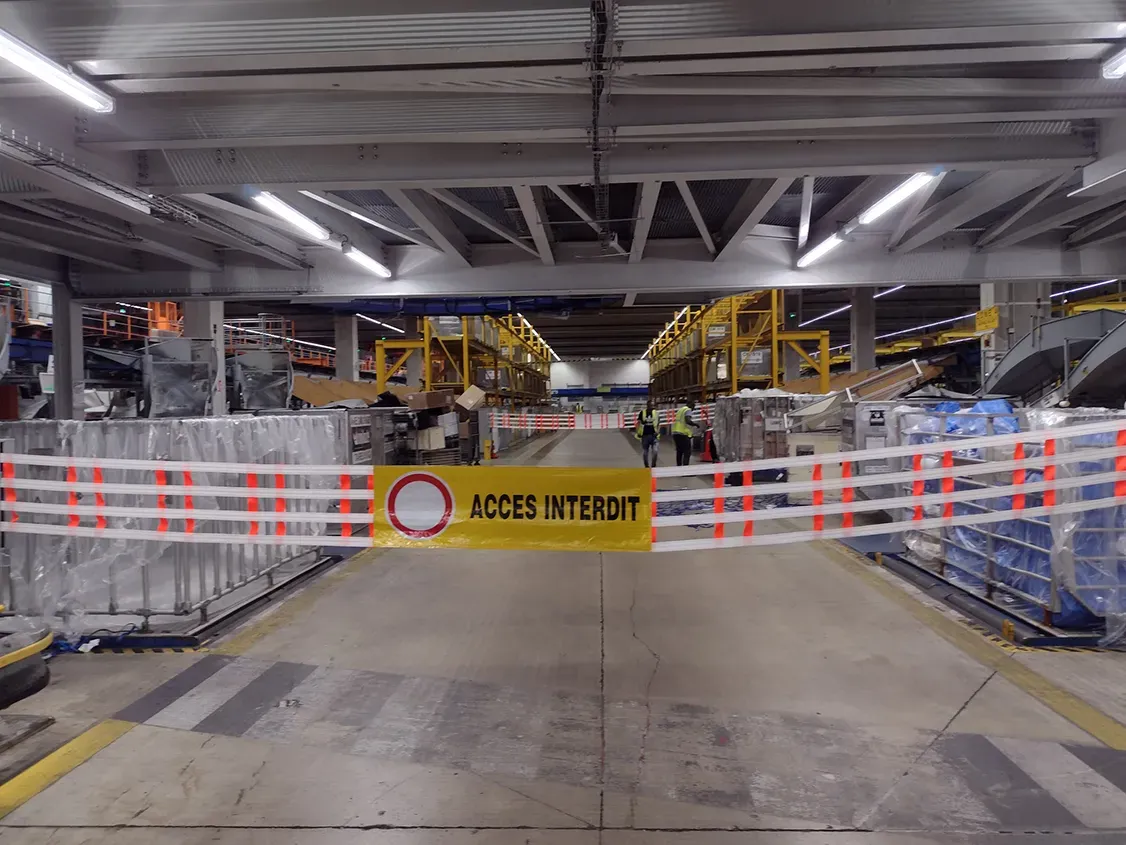 Barrière textile ACCÈS INTERDIT fermant une allée de site logistique